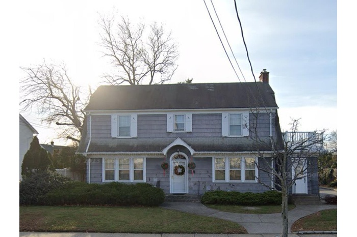 Dutch colonial featuring a front yard and a chimney
