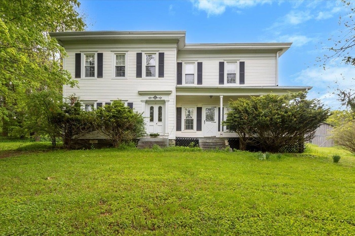 View of front facade with a front lawn and covered porch