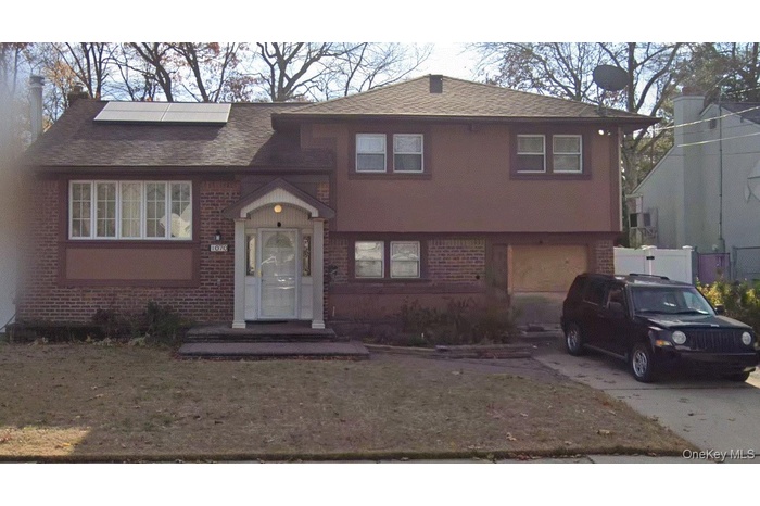 View of front of home featuring brick siding, concrete driveway, an attached garage, and a shingled roof
