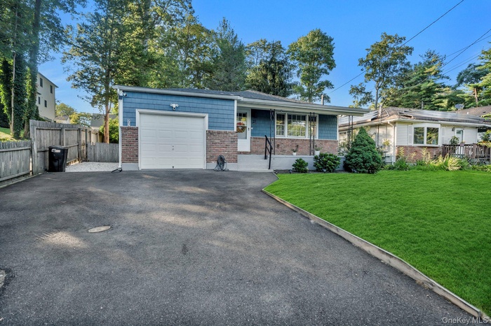 View of front facade featuring an attached garage, driveway, and brick siding