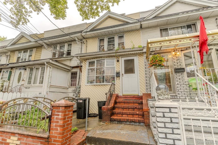 View of front of home featuring entry steps, a fenced front yard, and a gate