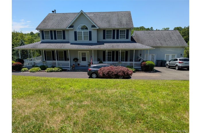 View of front of property with a porch, a front lawn, and a chimney