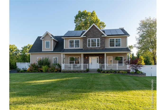 View of front of home with a porch and roof mounted solar panels