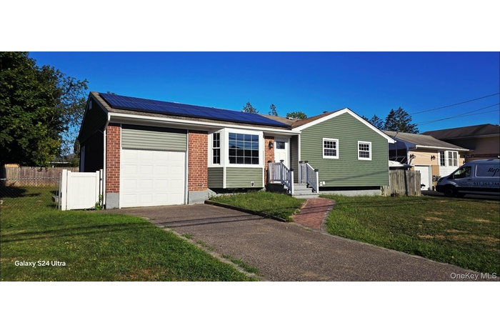 Ranch-style house with solar panels, brick siding, a garage, driveway, and a shingled roof