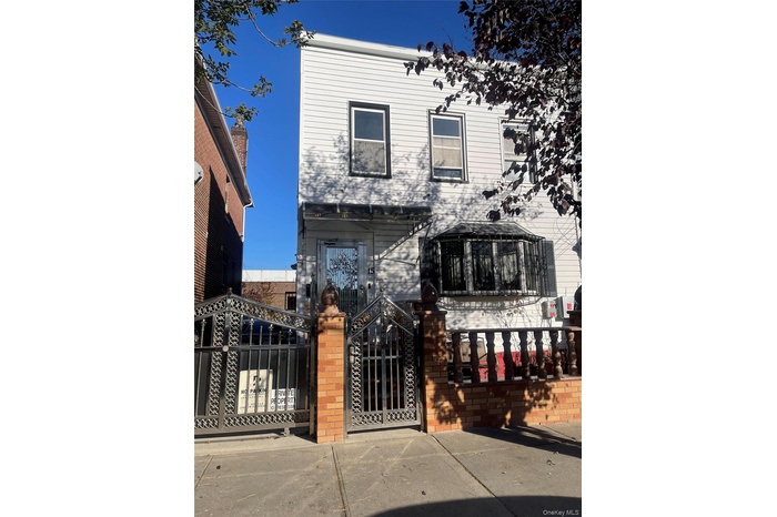 View of front facade with a fenced front yard and a gate