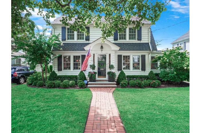 View of front facade with a shingled roof and a front yard