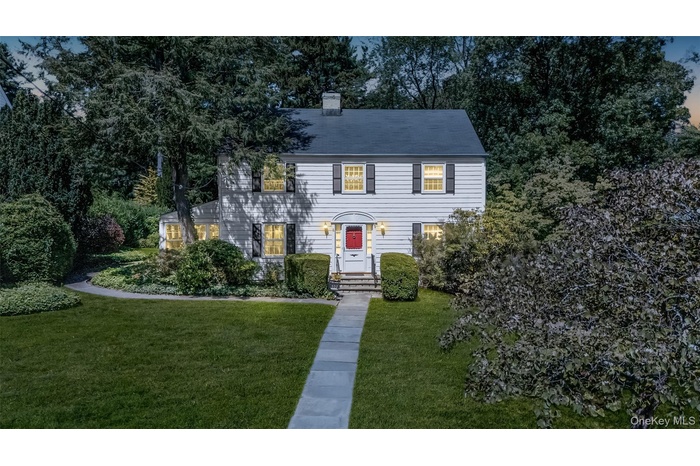 Colonial home with a front yard and a chimney
