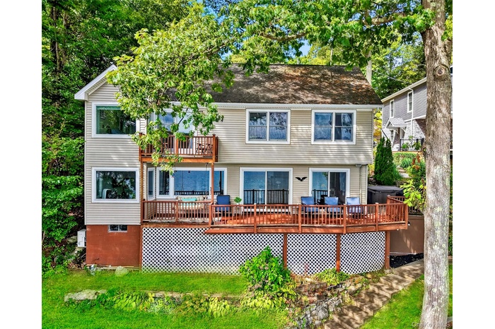 Rear view of house featuring a balcony and a wooden deck