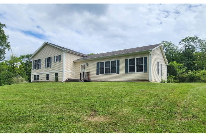 Rear view of property with a yard