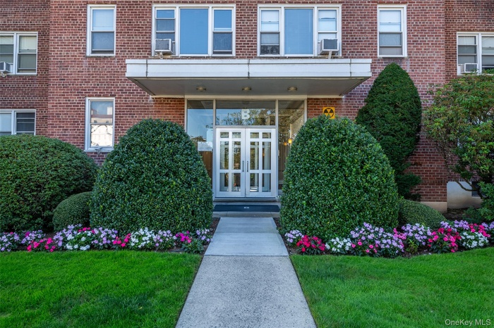 Doorway to property featuring brick siding and a yard