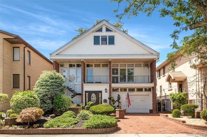 View of front of house featuring decorative driveway, an attached garage, stairway, and a balcony