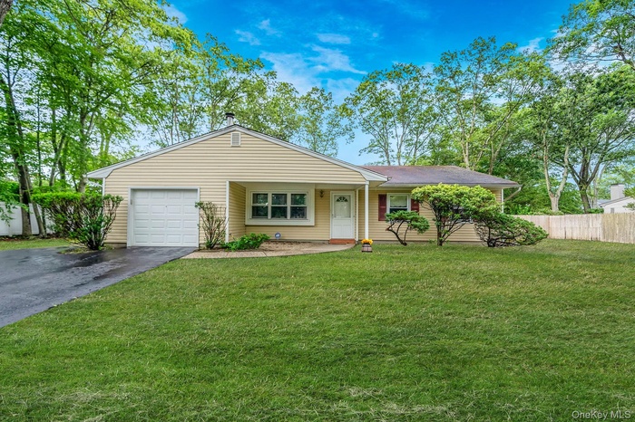 Ranch-style house with a garage and asphalt driveway
