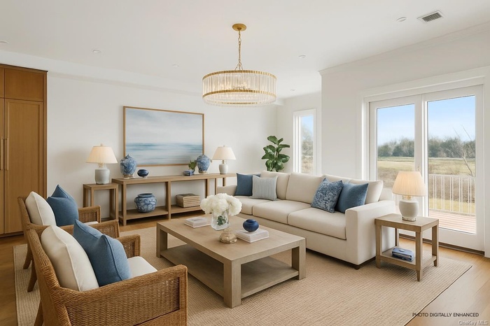 Living area featuring light wood finished floors, a chandelier, and crown molding