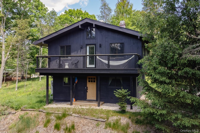 View of front of property featuring a chimney and a wooden deck