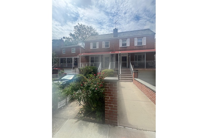 View of front facade with stairway, a porch, a chimney, and an attached garage