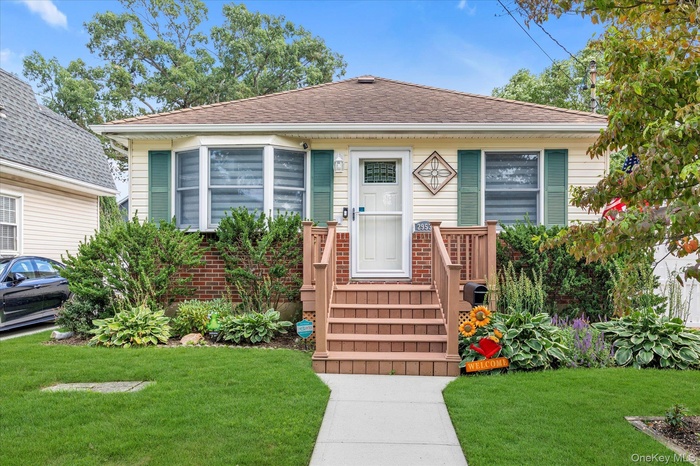 View of front of house with roof with shingles and a front lawn