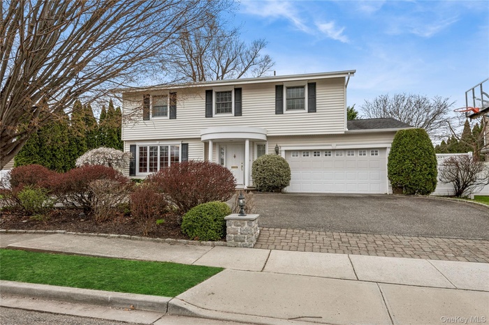 Colonial inspired home featuring driveway and a garage