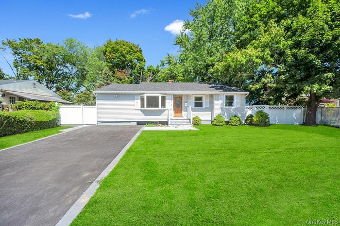 Ranch-style house with asphalt driveway and a chimney
