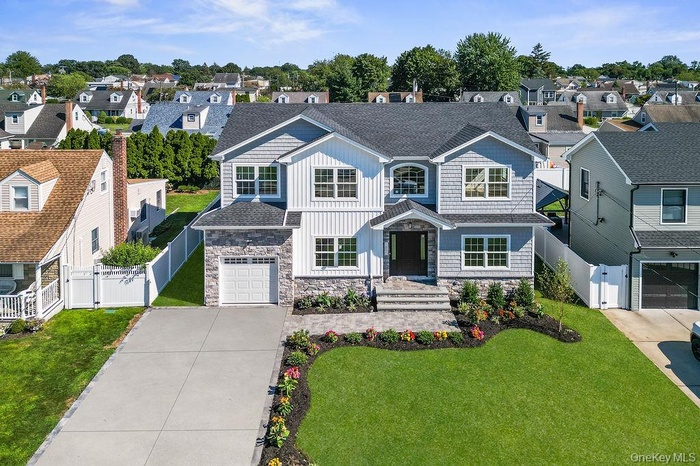 View of front of home featuring a residential view, a gate, driveway, and roof with shingles