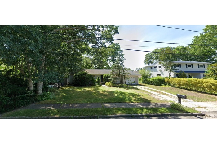View of front of home featuring a front yard and a garage