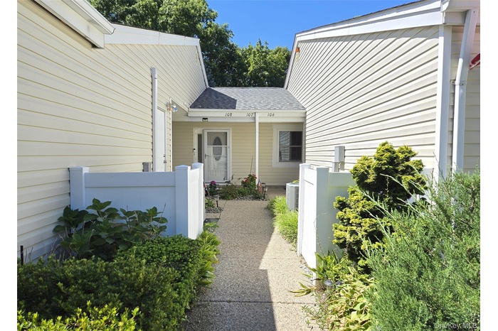 View of exterior entry with a shingled roof