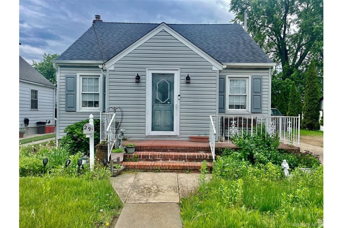 View of front of home with a shingled roof and a porch