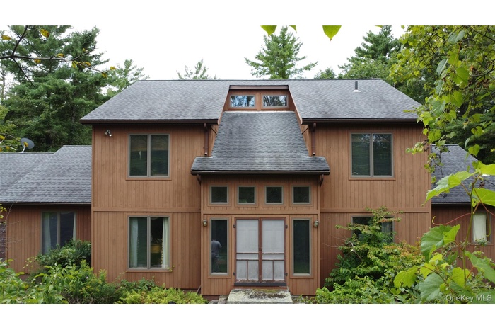 Back of property with roof with shingles