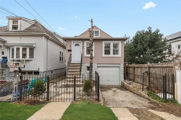 Grass virtually staged - View of front of house with aphalt driveway, fence, a garage, and stucco siding