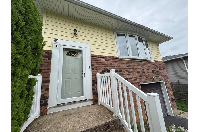 Doorway to property featuring brick siding and an attached garage