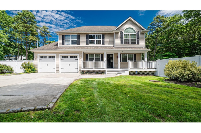 Traditional-style home featuring concrete driveway, a porch, a garage, and roof with shingles