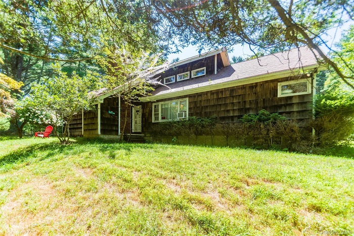Rear view of property with a yard and a shingled roof