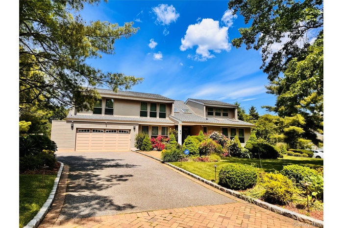 View of front of property with driveway and an attached garage