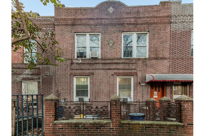 Townhome / multi-family property with brick siding and fence