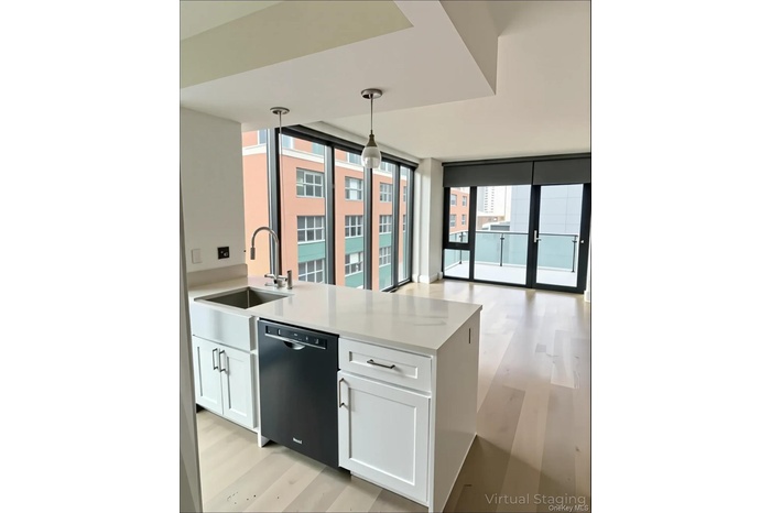 Kitchen featuring white cabinets, light wood-style flooring, light stone countertops, black dishwasher, and pendant lighting