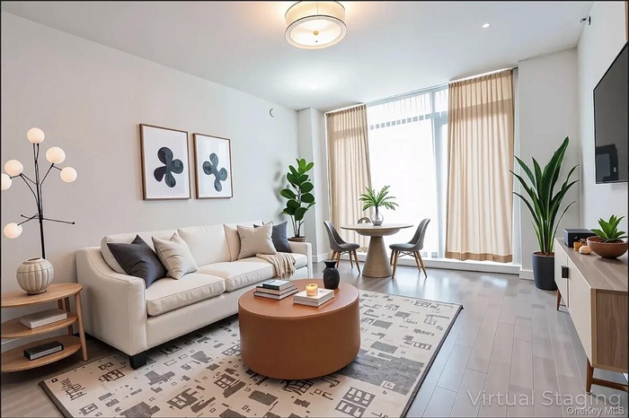 Living area featuring light wood-type flooring and floor to ceiling windows
