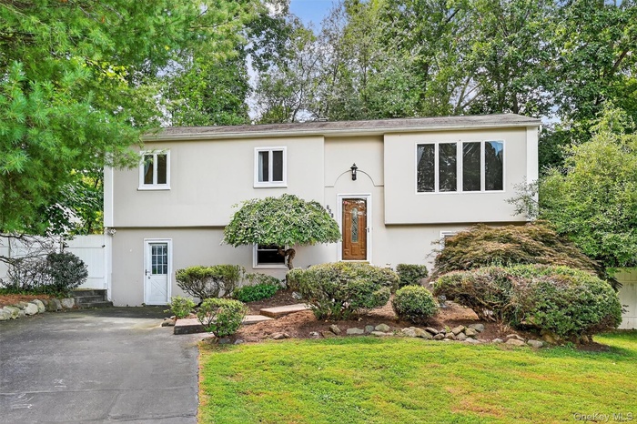 Raised ranch featuring stucco siding and driveway