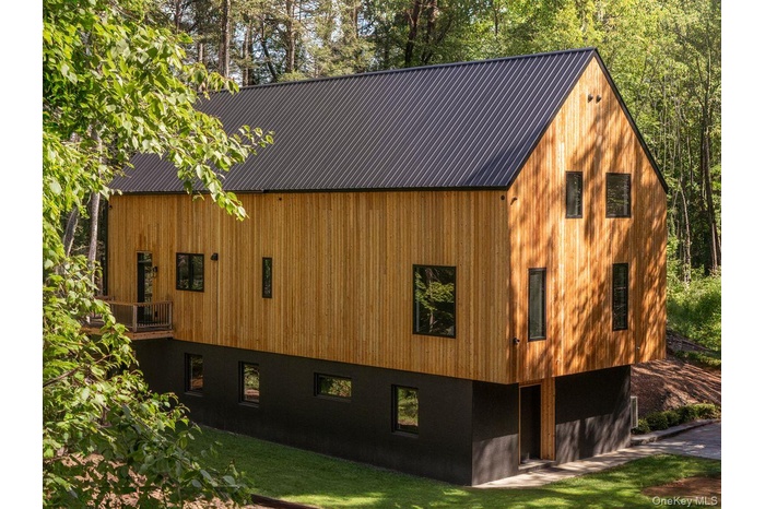 View of side of property with a metal roof and a yard