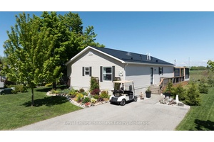A gardeners paradise ! ! Stunning perennial gardens line the front of this 2009 Hart Home, now being offered for sale in the lakefront adult community, Meneset on the Lake.