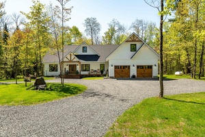 Welcome to this sprawling executive bungalow, built in 2022 and beautifully set on nearly 5 acres of lush, level land.