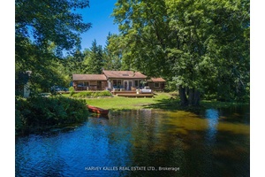 Charming and fully updated 4 season round log cottage on the Muskoka River, set on a rare double lot with 3.
