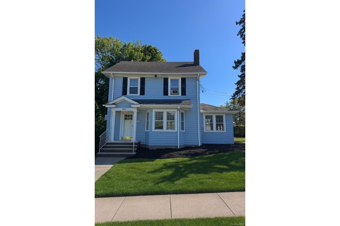 View of front of house featuring a front yard and a chimney