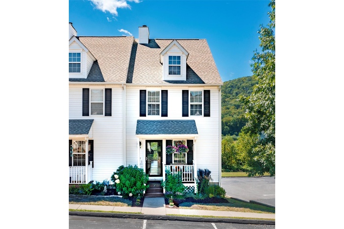 View of front of house featuring a chimney, roof with shingles, and covered porch