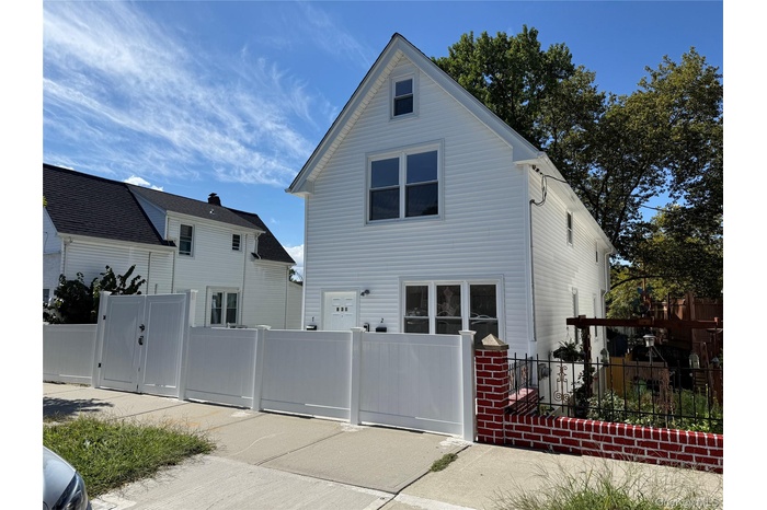 View of side of home with a fenced front yard and a gate