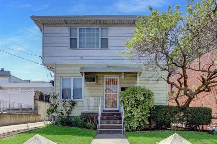 View of front of home with fence and a front yard