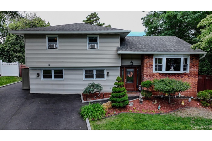 Tri-level home featuring brick siding and a shingled roof