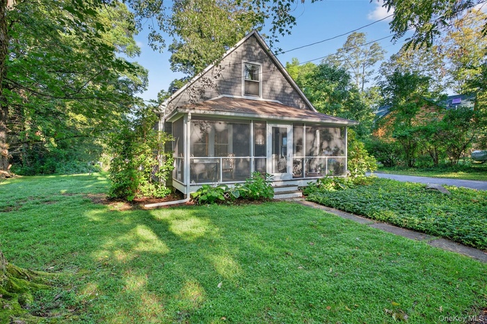 Rear view of property with a sunroom and a yard