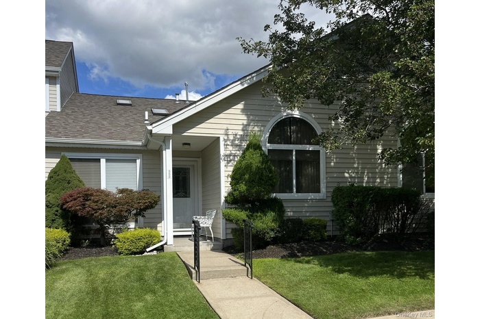 View of front facade with a front lawn and a shingled roof