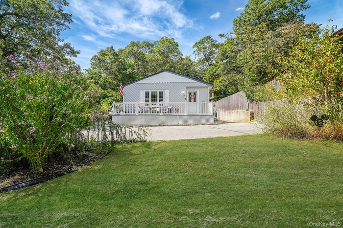 Front of house featuring a deck and view of scattered trees