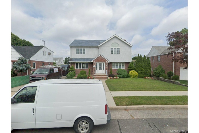 Traditional-style house featuring brick siding and a front yard
