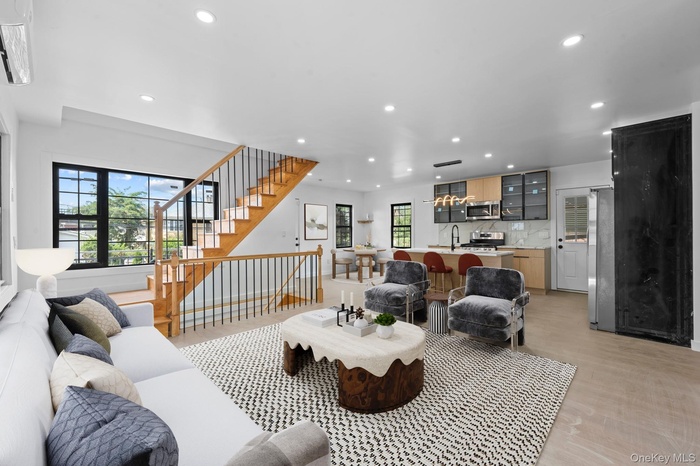 Living area with recessed lighting, light wood-type flooring, and stairs